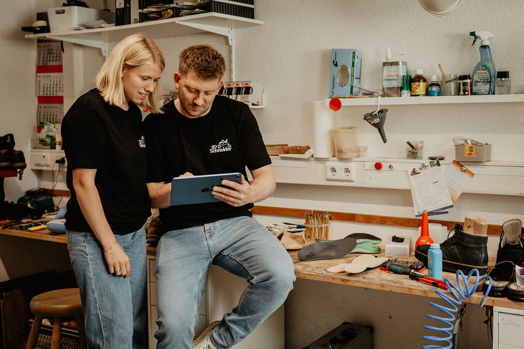Das Team von Go Schneider bespricht einen Auftrag am Tablet